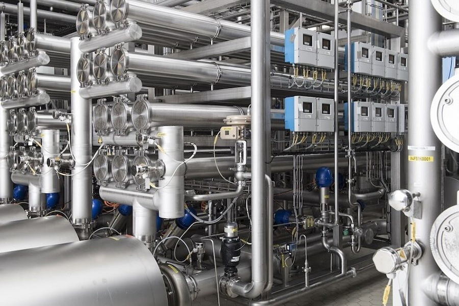 Technician inspecting industrial instrumentation in a plant