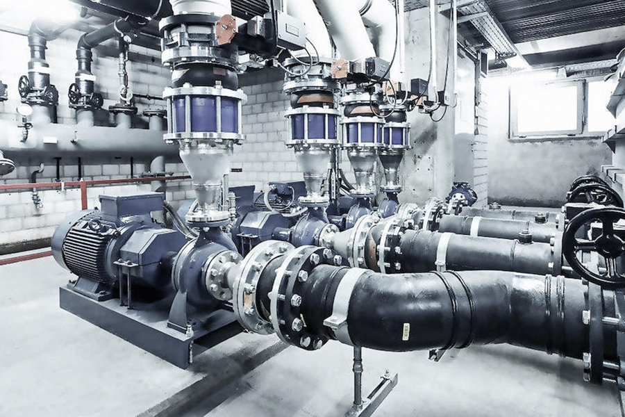 Blue industrial pumps and stainless steel process piping